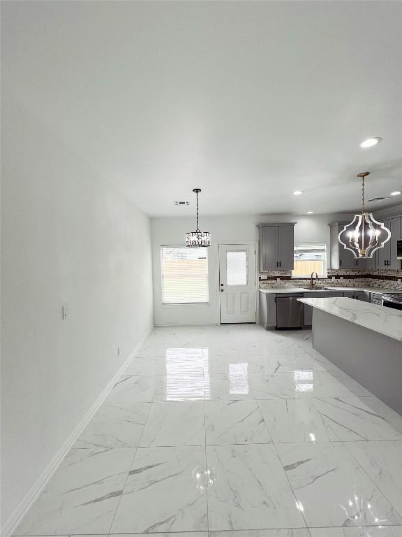 kitchen with stainless steel dishwasher, baseboards, a notable chandelier, and recessed lighting