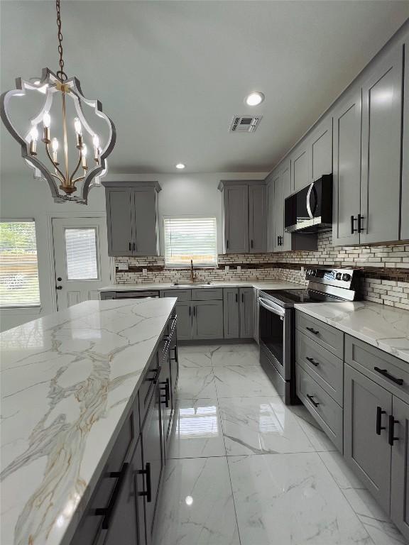 kitchen featuring gray cabinets, decorative backsplash, stainless steel electric range, and visible vents