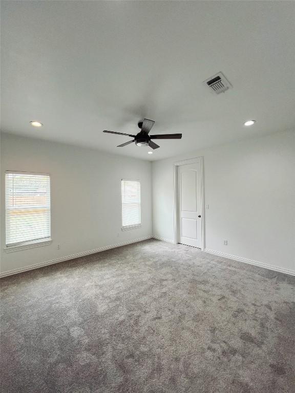 carpeted spare room featuring recessed lighting, visible vents, baseboards, and ceiling fan