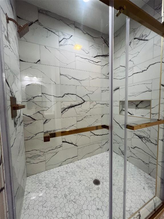 bathroom featuring a marble finish shower