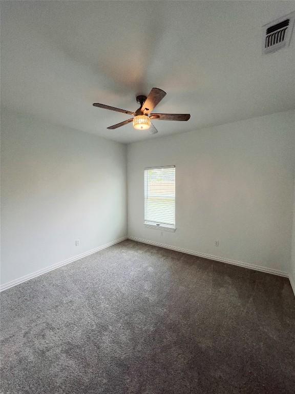 spare room with visible vents, carpet flooring, baseboards, and a ceiling fan