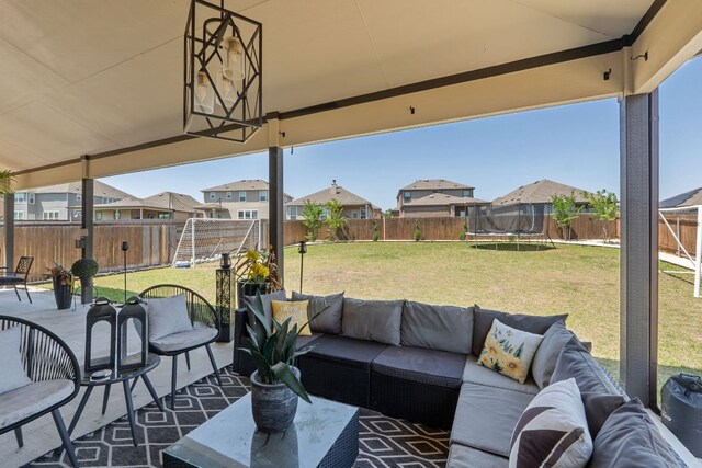 245 Six Shooter Dr, Kyle, TX 78640 - fenced backyard featuring a residential view, an outdoor hangout area, a trampoline, and a patio area