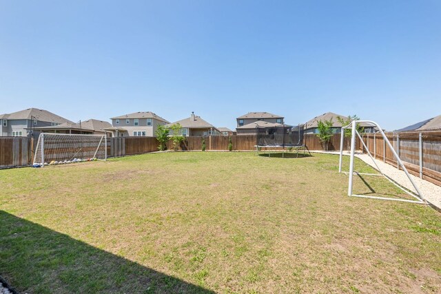 245 Six Shooter Dr, Kyle, TX 78640 - fenced backyard featuring a trampoline and a residential view