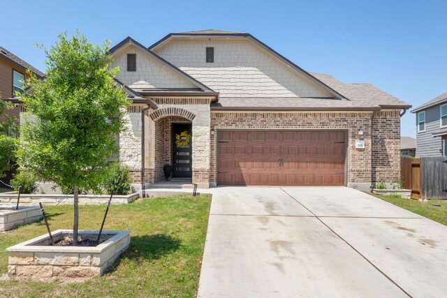 245 Six Shooter Dr, Kyle, TX 78640 - view of front of house with a garage, driveway, and brick siding