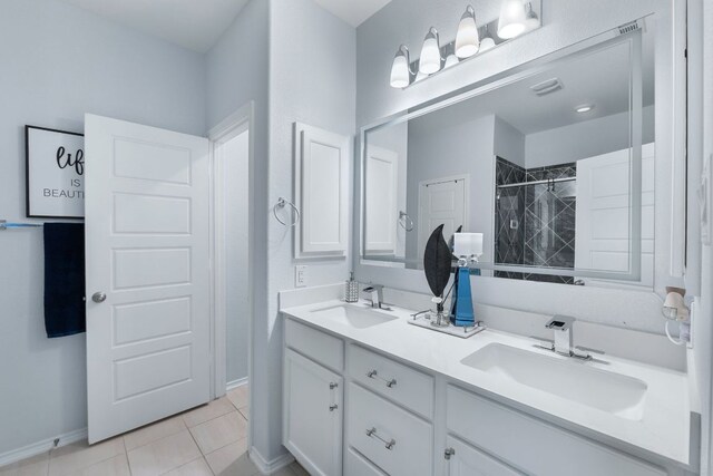 245 Six Shooter Dr, Kyle, TX 78640 - bathroom featuring double vanity, tiled shower, and tile patterned flooring