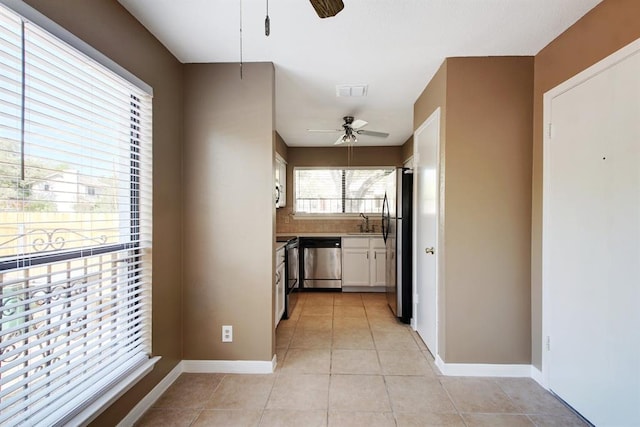 8142 Ceberry Dr Unit B, Austin, TX 78759 - kitchen with ceiling fan, appliances with stainless steel finishes, a sink, white cabinets, and light tile patterned flooring