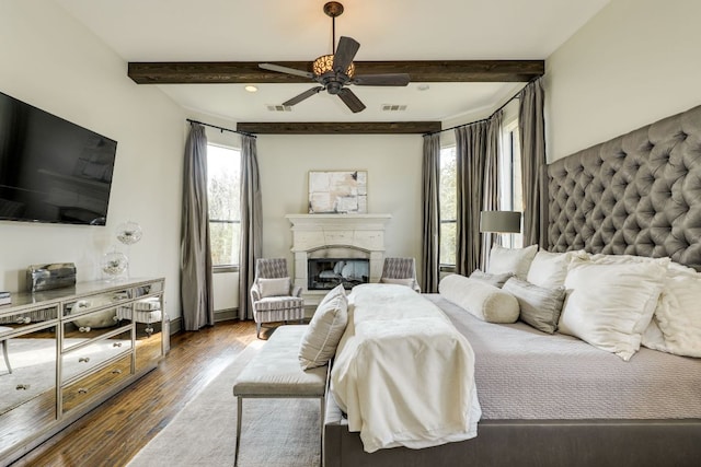 2104 University Club Dr, Austin, TX 78732 - bedroom featuring beam ceiling, wood finished floors, a fireplace with raised hearth, and ceiling fan