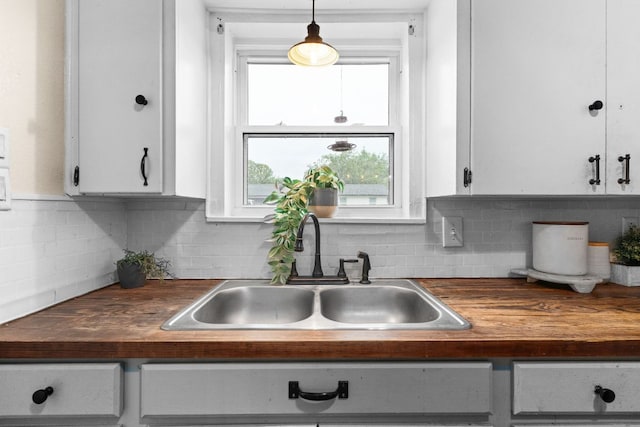 26 N Castleberry St, Lampasas, TX 76550 - kitchen featuring a sink, wooden counters, decorative backsplash, and white cabinets