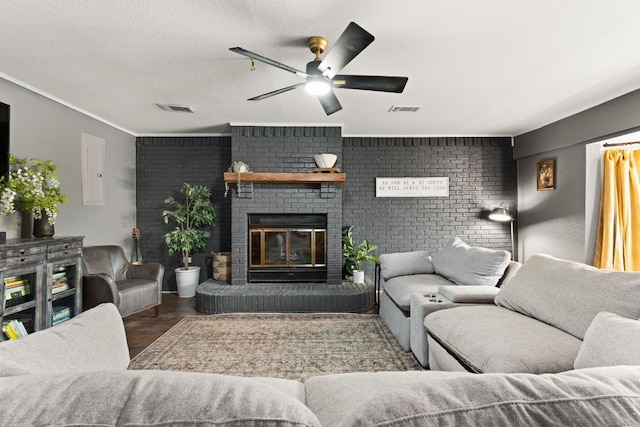 26 N Castleberry St, Lampasas, TX 76550 - living room with a ceiling fan, wood finished floors, a fireplace, brick wall, and electric panel