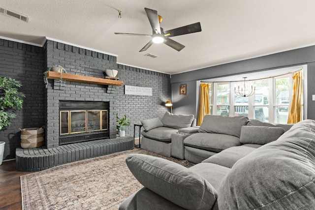 26 N Castleberry St, Lampasas, TX 76550 - living area with a brick fireplace, ceiling fan with notable chandelier, dark wood-type flooring, and visible vents