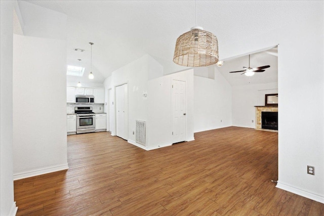 unfurnished living room with lofted ceiling, a ceiling fan, visible vents, and wood finished floors