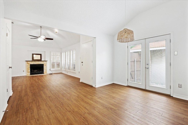 unfurnished living room featuring wood finished floors, vaulted ceiling, french doors, and ceiling fan
