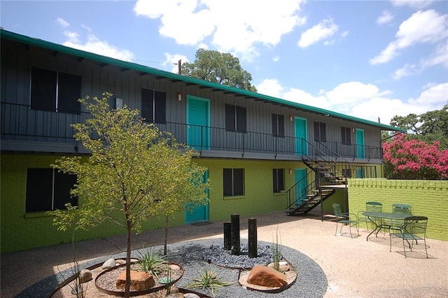 view of property's community with stairs and a patio