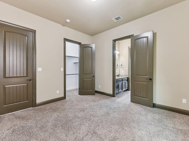 6120 Gunnison Turn Rd, Austin, TX 78738 - unfurnished bedroom with a walk in closet, light carpet, baseboards, and ensuite bath