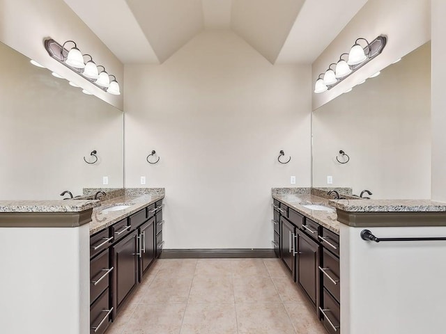 6120 Gunnison Turn Rd, Austin, TX 78738 - full bathroom with two vanities, tile patterned flooring, lofted ceiling, and baseboards