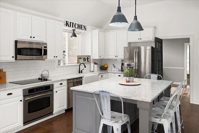 134 Brentwood Dr, Georgetown, TX 78628 - kitchen with appliances with stainless steel finishes, white cabinetry, backsplash, a sink, and vaulted ceiling