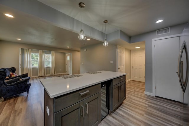 417 Big Bow, Smithville, TX 78957 - kitchen featuring light wood finished floors, light countertops, visible vents, hanging light fixtures, and open floor plan
