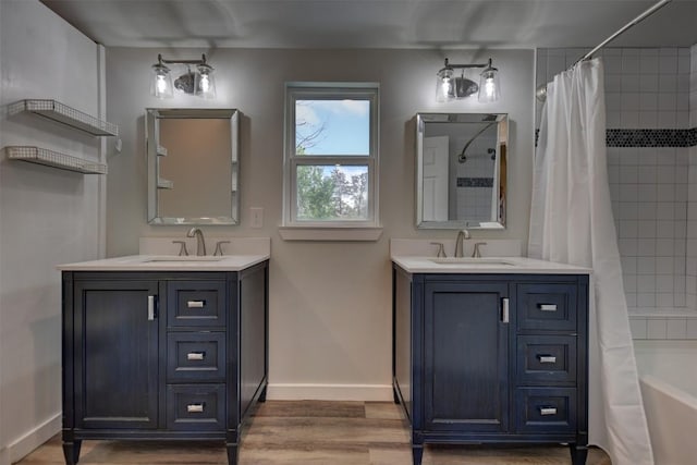 417 Big Bow, Smithville, TX 78957 - bathroom with two vanities, wood finished floors, baseboards, and a sink