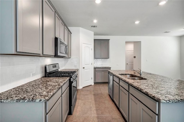 265 Spanish Star Trl, Dripping Springs, TX 78620 - kitchen with appliances with stainless steel finishes, a sink, gray cabinetry, stone countertops, and backsplash