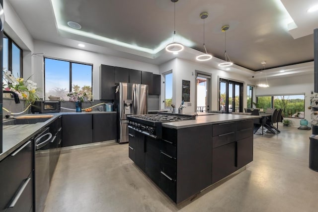 kitchen with modern cabinets, a tray ceiling, and dark cabinets