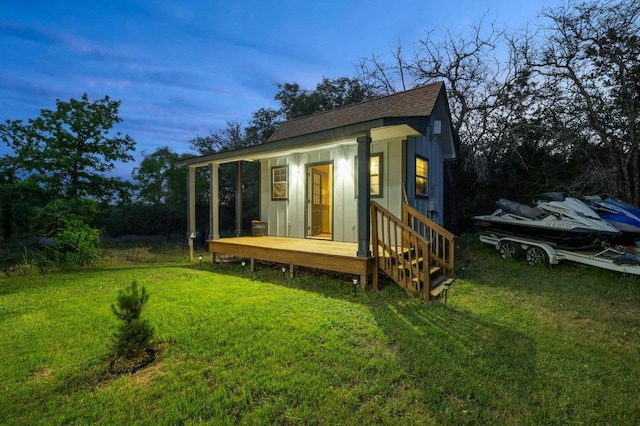 outdoor structure at dusk featuring an outdoor structure and a yard