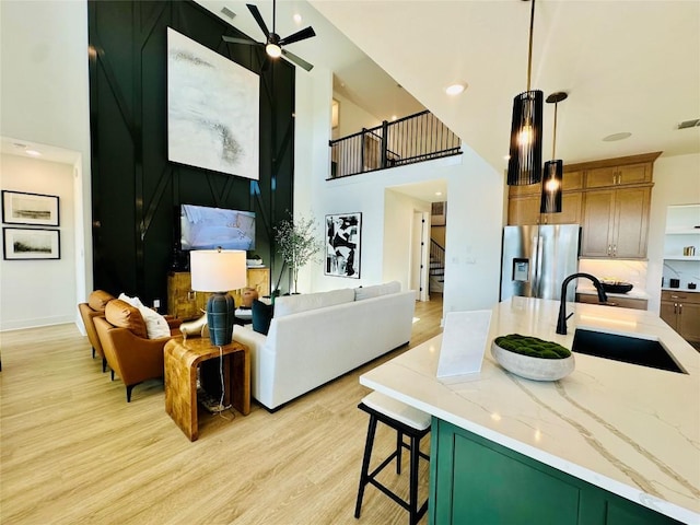 1603 Headwaters Blvd, Dripping Springs, TX 78620 - living area featuring stairway, a towering ceiling, light wood-style floors, and ceiling fan