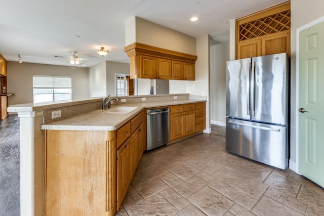 208 Saddletree Ln, Dripping Springs, TX 78620 - kitchen featuring appliances with stainless steel finishes, a sink, ceiling fan, light stone countertops, and a peninsula