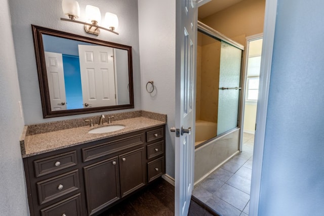 208 Saddletree Ln, Dripping Springs, TX 78620 - full bathroom featuring vanity, bath / shower combo with glass door, tile patterned flooring, and baseboards