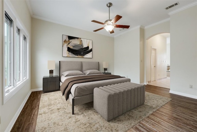 5004 Arrowhead Dr, Lago Vista, TX 78645 - bedroom with wood finished floors, arched walkways, crown molding, baseboards, and a ceiling fan