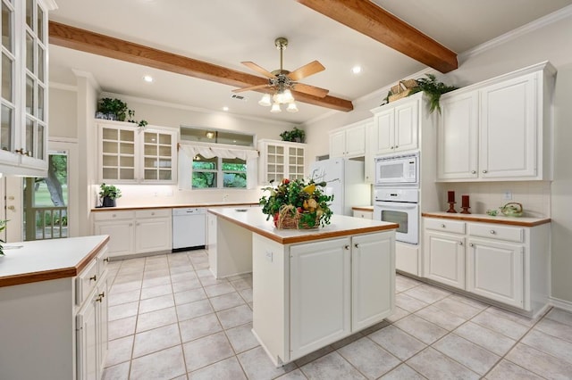 kitchen with light countertops, beam ceiling, white appliances, and a kitchen island