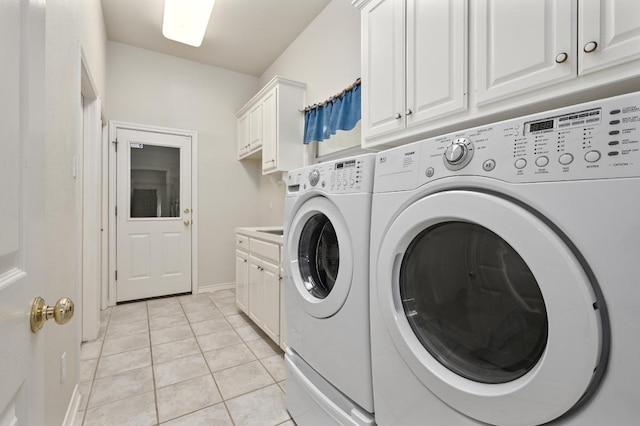 laundry room with baseboards, washer and dryer, light tile patterned floors, and cabinet space