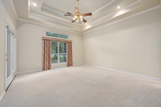 spare room featuring a raised ceiling, visible vents, crown molding, and ceiling fan