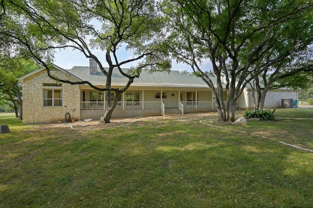single story home with a porch, stone siding, and a front yard