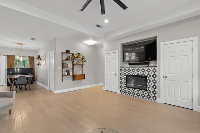 living room featuring visible vents, ceiling fan, light wood-style flooring, and baseboards