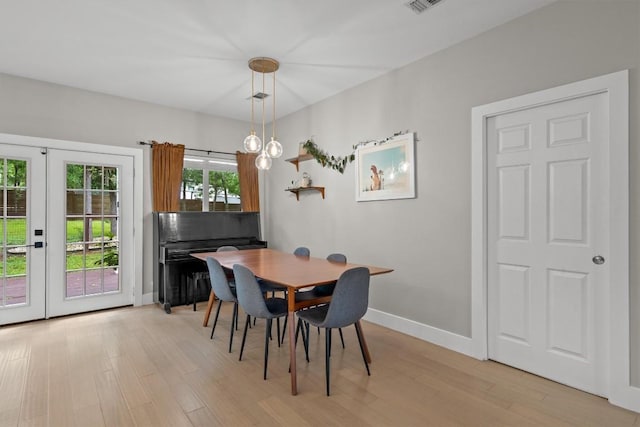 dining room with light wood finished floors, visible vents, french doors, and baseboards