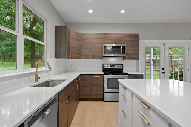 kitchen featuring recessed lighting, a sink, appliances with stainless steel finishes, and a healthy amount of sunlight