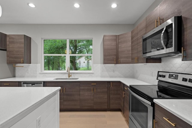 kitchen featuring recessed lighting, stainless steel appliances, light countertops, and a sink