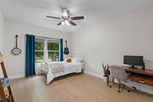 bedroom featuring ceiling fan, wood finished floors, and baseboards