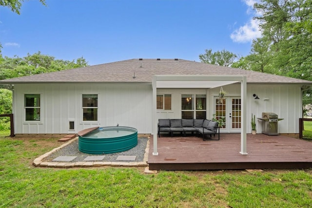 back of property with outdoor lounge area, a deck, a shingled roof, and french doors
