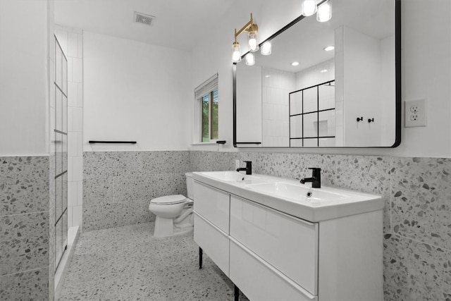 bathroom with toilet, tile walls, visible vents, and a shower stall