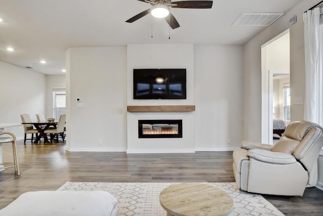 living area with recessed lighting, wood finished floors, visible vents, and ceiling fan