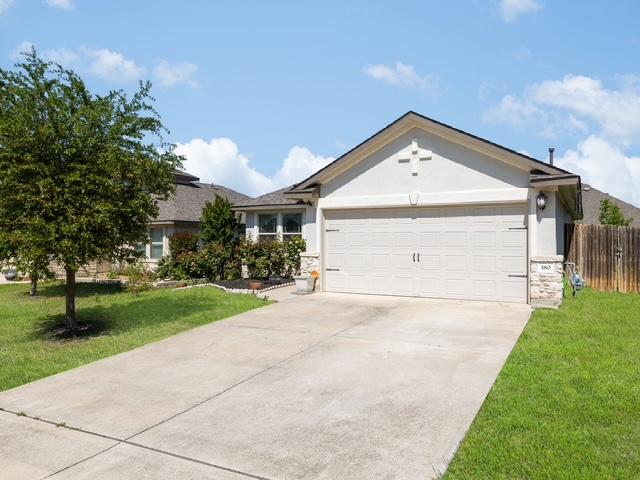 180 Tailwind Dr, Kyle, TX 78640 - single story home with an attached garage, concrete driveway, stone siding, and stucco siding