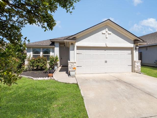 180 Tailwind Dr, Kyle, TX 78640 - ranch-style home with an attached garage, driveway, stone siding, and stucco siding