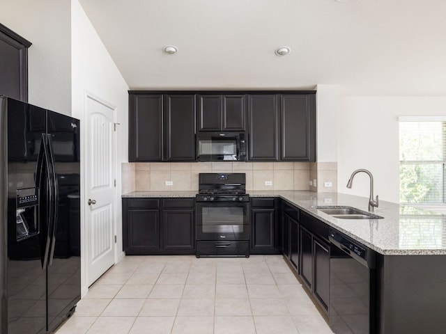 180 Tailwind Dr, Kyle, TX 78640 - kitchen with black appliances, light stone countertops, a peninsula, and backsplash