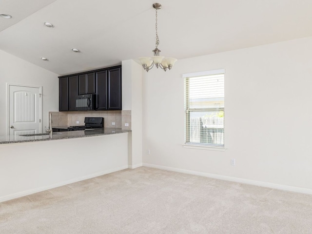 180 Tailwind Dr, Kyle, TX 78640 - kitchen featuring black microwave, a chandelier, stove, dark stone countertops, and vaulted ceiling