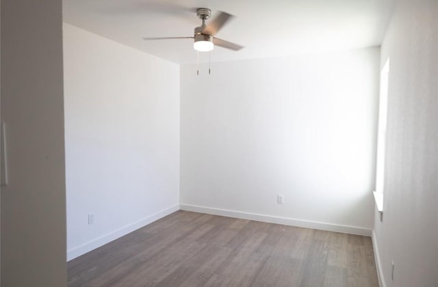 spare room featuring baseboards, a ceiling fan, and wood finished floors