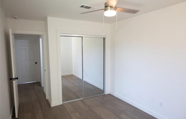 unfurnished bedroom with wood finished floors, a closet, ceiling fan, baseboards, and visible vents