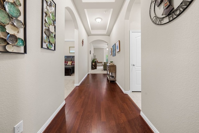 535 Tranquility Mtn, Buda, TX 78610 - hallway featuring arched walkways, wood finished floors, a tray ceiling, and baseboards