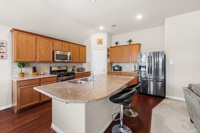 535 Tranquility Mtn, Buda, TX 78610 - kitchen with stainless steel appliances, a sink, an island with sink, backsplash, and light stone counters