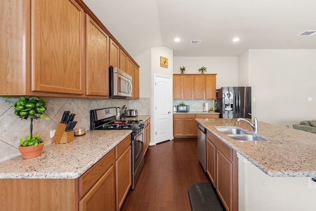 535 Tranquility Mtn, Buda, TX 78610 - kitchen with stainless steel appliances, a sink, light stone countertops, dark wood-style flooring, and backsplash